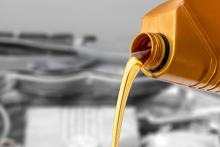 Compressor Oils being poured from an orange bottle